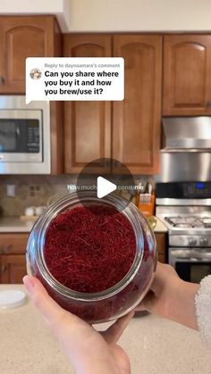 someone is holding up a jar with red stuff in it