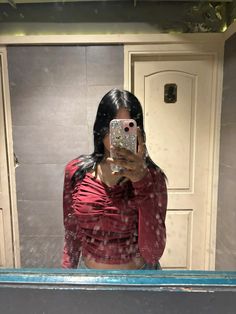 a woman taking a selfie in front of a mirror with water droplets on it