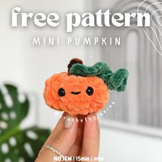 a hand holding a small stuffed toy with a pumpkin on it's head and the words free pattern above it