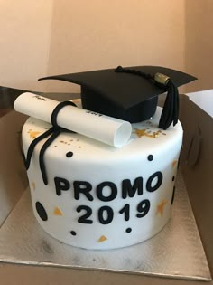 a graduation cake is decorated with white frosting and black lettering that reads prom 2019