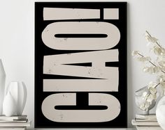 a black and white poster sitting on top of a wooden shelf next to vases