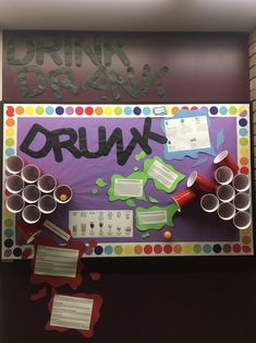 a bulletin board with the word drunk written on it and lots of cups in front of it