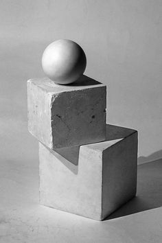 black and white photograph of an object sitting on top of cement blocks with one ball