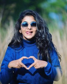 a woman making a heart shape with her hands