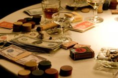 a table topped with lots of money and wine glasses