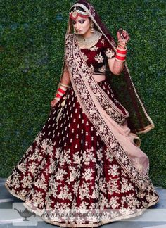 a woman in a red and gold bridal gown with her hand on her hip