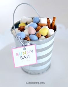 a bucket filled with candy sitting on top of a white table next to a sign