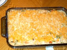 a casserole dish with cheese and vegetables in it on a wooden table top