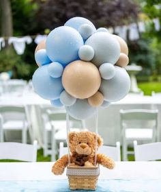 a teddy bear in a basket with balloons