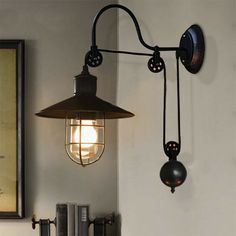 an old fashioned lamp hanging from the side of a wall next to a book shelf