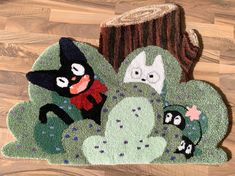 a rug with cartoon characters on it sitting on a wooden floor next to a potted plant