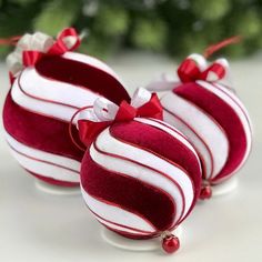 two red and white ornaments with bows on them