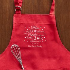 a red apron with a whisk on it and the words, bliss is the food that family needs to make and love between us