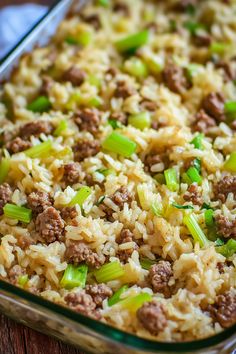 a casserole dish with meat and rice in it on a wooden table top