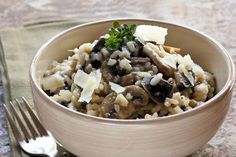 a close up of a bowl of food on a table with a fork next to it