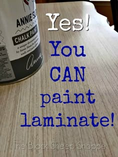 a can of paint sitting on top of a table with the words yes you can paint laminate