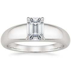 an emerald cut diamond engagement ring on a white background