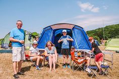 a group of people standing around a blue tent