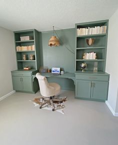 a room with a desk, bookshelf and chair in it's corner