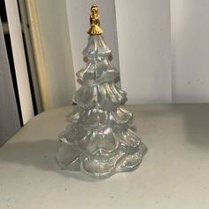 a glass christmas tree sitting on top of a table