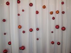 red and gold ornaments are hanging on the curtain