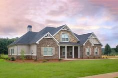 a large brick house sitting on top of a lush green field