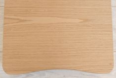 a wooden cutting board sitting on top of a white counter next to a knife and fork