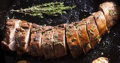 sliced meat on a grill with herbs and garlic