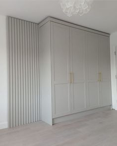 an empty room with white walls and grey cupboards