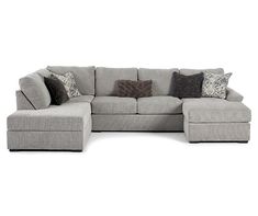 a large sectional couch with pillows on the top and bottom corner, in grey fabric