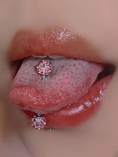 a close up of a person's tongue with a pink diamond ring on it