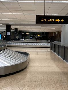 an empty baggage claim area at the airport with signs above it that say arrivals and departures