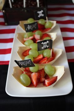 some fruit is on a white plate with black signs and red striped tablecloths