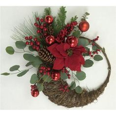 a christmas wreath with poinsettis, greenery and red baubles