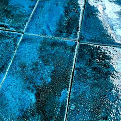 a blue tile floor that has been cleaned and is covered with water droplets from the rain