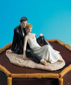 a bride and groom figurine sitting on top of a table