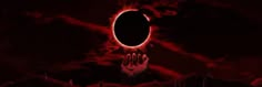 a hand reaching out to an eclipse in the night sky with clouds and red hues