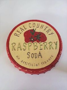 a raspberry soda bottle cap with the words real country soap on it's side