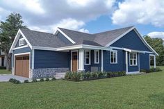 a blue house with two garages on the front and one car attached to it