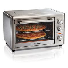 two pizzas are being cooked in an electric toaster oven on a white background