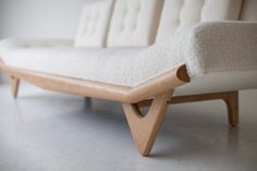 a white couch sitting on top of a wooden frame