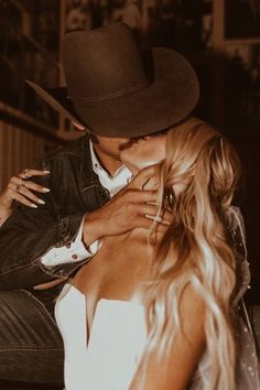 a man in a cowboy hat kissing a woman