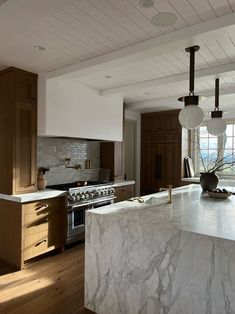 a large kitchen with marble counter tops and wooden cabinets, along with an island in the middle