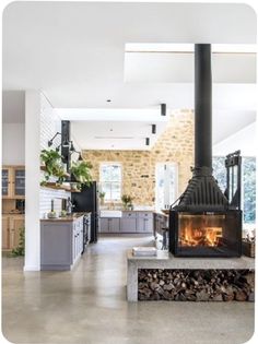 an open kitchen with a fireplace in the center