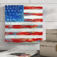 an american flag painted on the side of a wall next to a stack of books