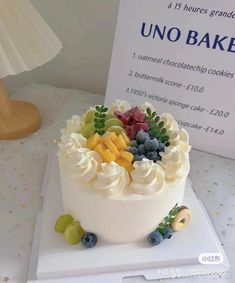 there is a cake with fruit on it and a sign in the background that says uno bake