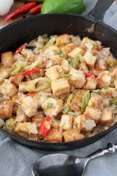 a skillet filled with tofu and vegetables