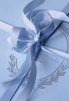 a blue ribbon tied on top of an envelope