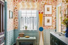 a bathroom with colorful wallpaper and pictures hanging on the walls, along with a bench