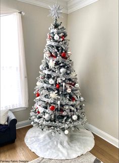 a white christmas tree with red and silver ornaments